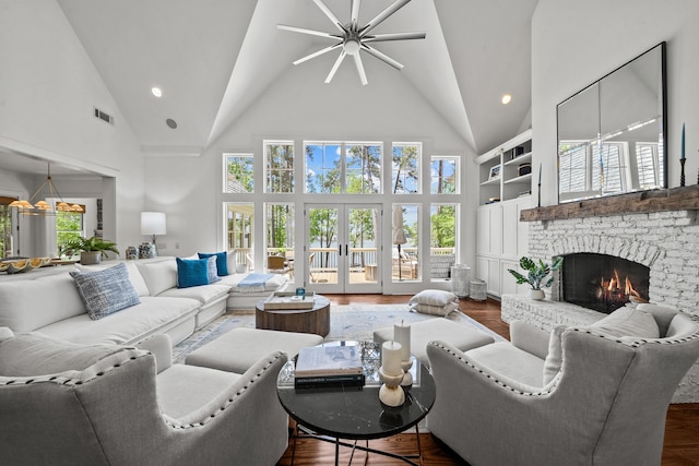 1081 Terrell Cir, Greensboro, GA 30642 - living area with high vaulted ceiling, ceiling fan, a brick fireplace, plenty of natural light, and dark wood finished floors