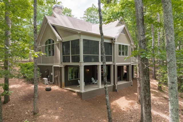 rear view of property featuring central AC, a sunroom, and a patio