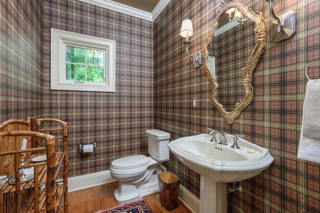 bathroom with hardwood / wood-style floors, ornamental molding, and toilet