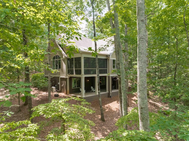 rear view of house featuring a patio area and a sunroom