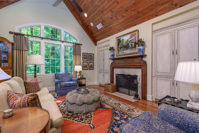 living room featuring wood-type flooring, a wealth of natural light, a fireplace, and high vaulted ceiling