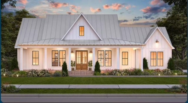 1010 Troon Ct, Greensboro, GA 30642 - modern farmhouse style home featuring a standing seam roof, french doors, a yard, covered porch, and board and batten siding