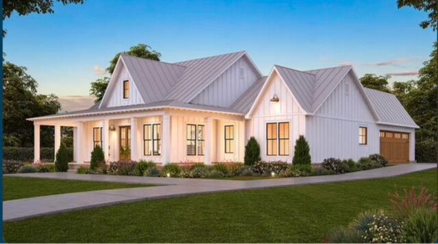 1010 Troon Ct, Greensboro, GA 30642 - modern farmhouse style home with board and batten siding, a standing seam roof, a garage, a lawn, and a metal roof