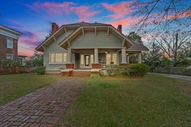 view of front of house with a porch and a lawn