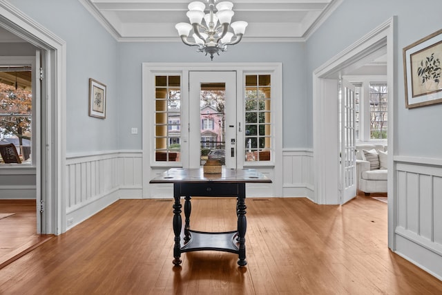 dining space featuring a notable chandelier, a wealth of natural light, ornamental molding, and light wood-type flooring