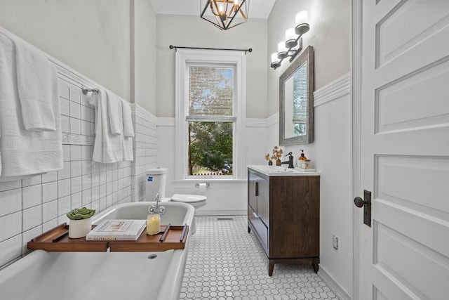 bathroom with vanity, a washtub, a chandelier, and toilet