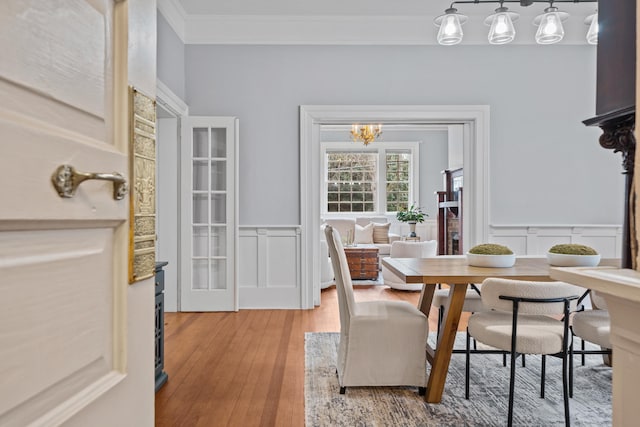 dining room with crown molding, hardwood / wood-style floors, and a notable chandelier