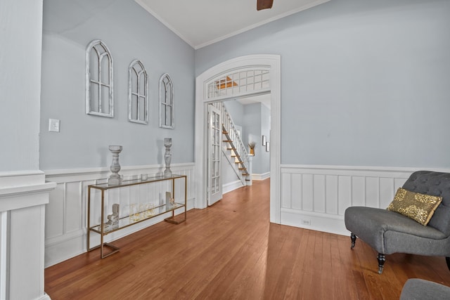 sitting room featuring ornamental molding and wood-type flooring