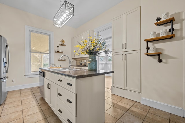 kitchen with a kitchen island with sink, sink, white cabinets, and appliances with stainless steel finishes