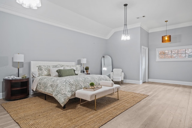 bedroom with crown molding, vaulted ceiling, and light hardwood / wood-style flooring