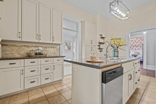 kitchen with white cabinetry, stainless steel dishwasher, sink, and an island with sink