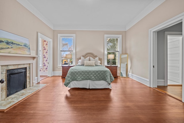 bedroom with hardwood / wood-style flooring, ornamental molding, and multiple windows