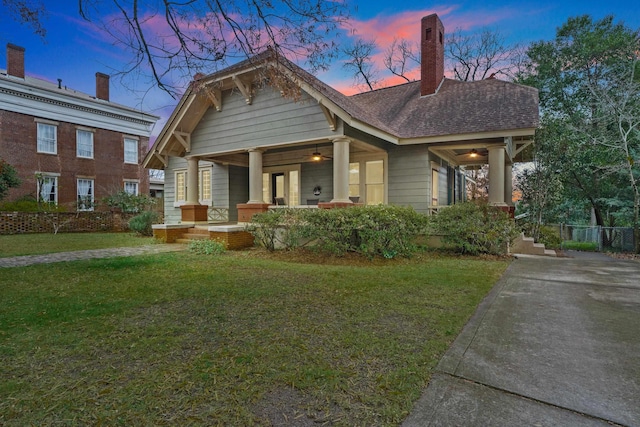 view of front of home featuring covered porch and a lawn