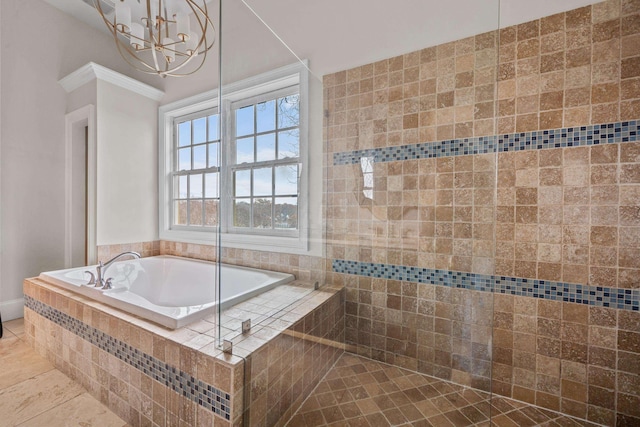 bathroom featuring tile patterned flooring, crown molding, tiled bath, and a chandelier