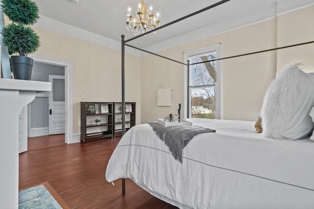 bedroom featuring dark hardwood / wood-style flooring, ornamental molding, and a chandelier