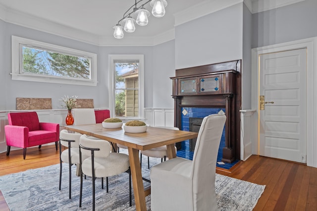 dining area featuring ornamental molding, an inviting chandelier, and dark hardwood / wood-style flooring