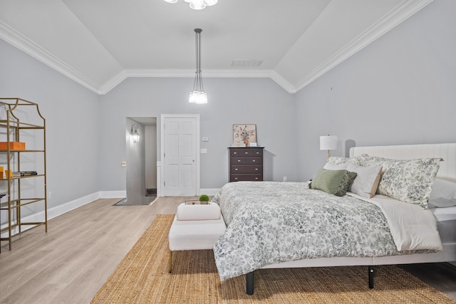 bedroom featuring hardwood / wood-style flooring, lofted ceiling, and crown molding