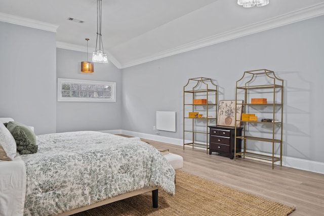 bedroom featuring ornamental molding, vaulted ceiling, and light hardwood / wood-style flooring