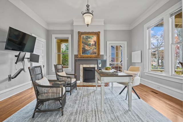 sitting room with ornamental molding and wood-type flooring