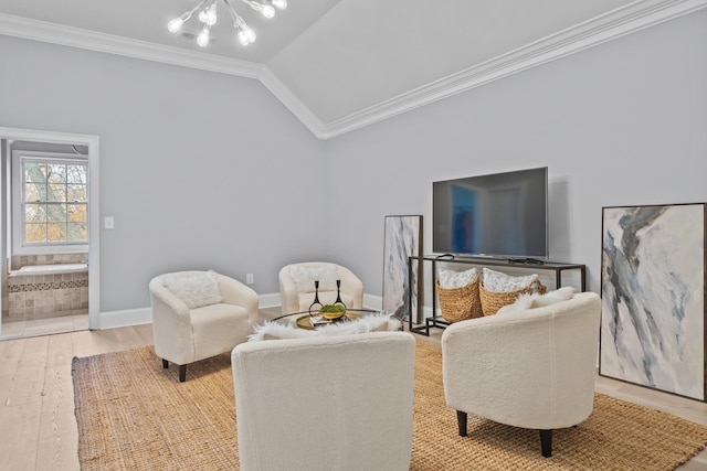 living room with vaulted ceiling, a notable chandelier, crown molding, and light hardwood / wood-style floors