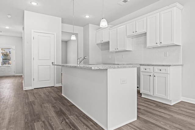 kitchen with sink, white cabinetry, hanging light fixtures, an island with sink, and dark hardwood / wood-style flooring