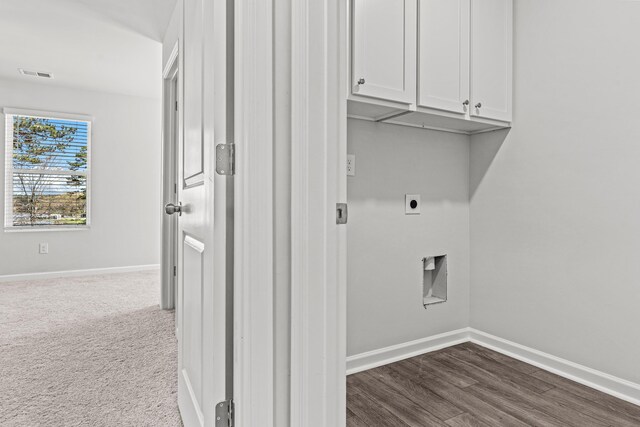 laundry area featuring cabinets, hookup for an electric dryer, and dark colored carpet