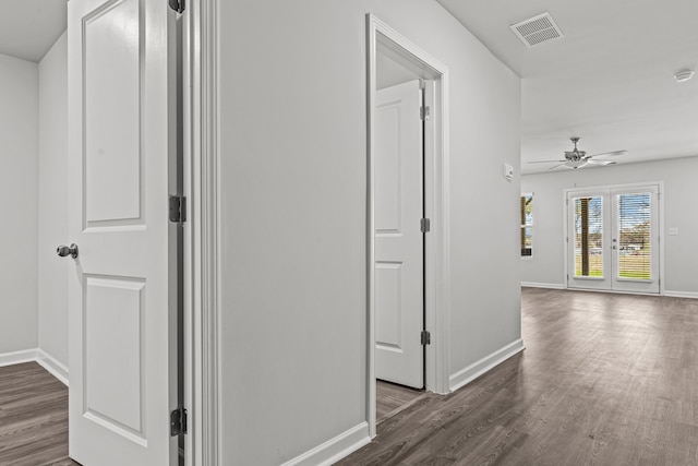 corridor with french doors and dark hardwood / wood-style flooring