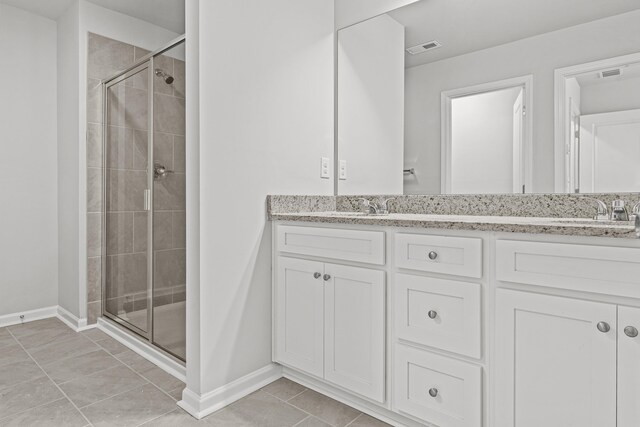 bathroom with vanity, an enclosed shower, and tile patterned flooring