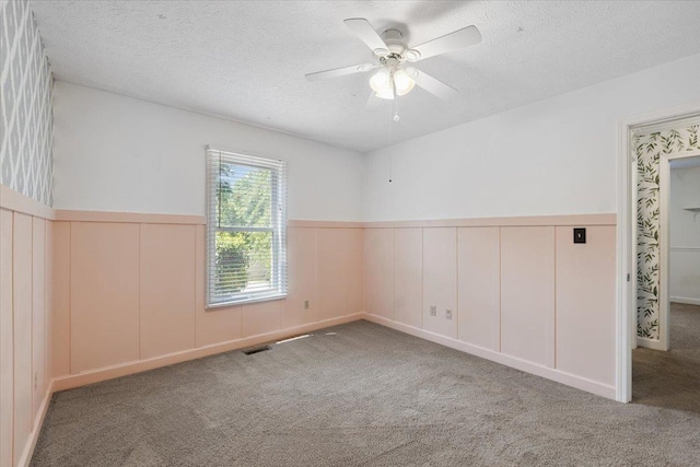 1120 Rawlings Dr, Rutledge, GA 30663 - carpeted empty room with wainscoting, a textured ceiling, and ceiling fan