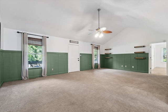 1120 Rawlings Dr, Rutledge, GA 30663 - unfurnished living room with lofted ceiling, ceiling fan, a wainscoted wall, carpet, and plenty of natural light