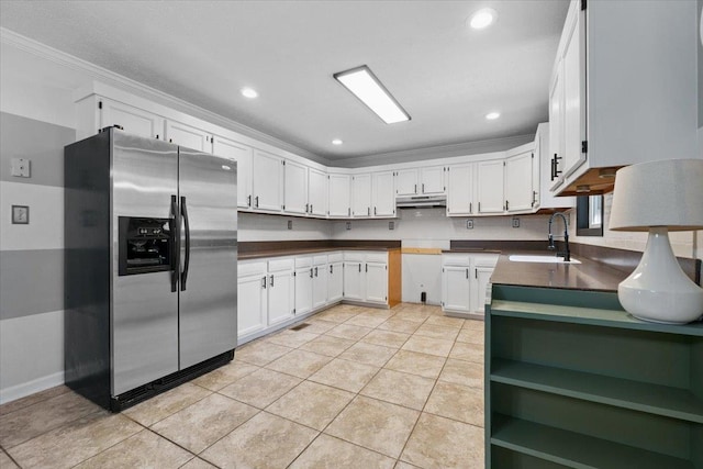 1120 Rawlings Dr, Rutledge, GA 30663 - kitchen featuring stainless steel refrigerator with ice dispenser, under cabinet range hood, dark countertops, ornamental molding, and light tile patterned floors