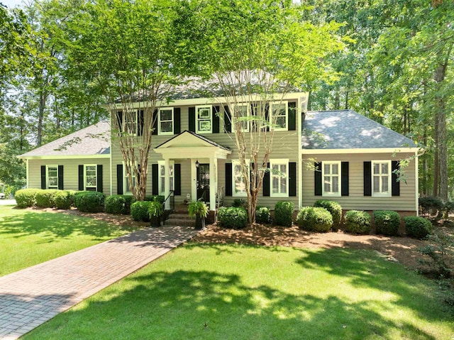 colonial-style house featuring a front yard