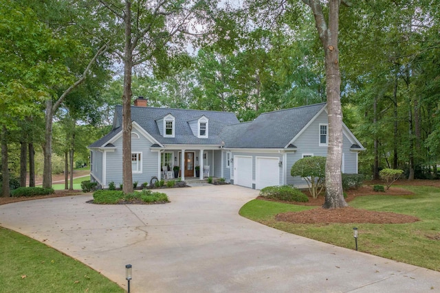 new england style home featuring a garage, a front yard, and covered porch