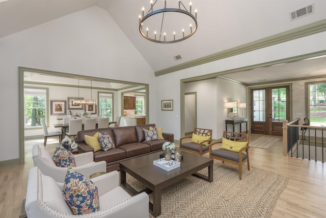 living room with ornamental molding, high vaulted ceiling, a wealth of natural light, and light wood-type flooring