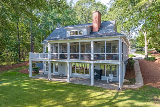 back of property with a yard, a sunroom, a patio, and ceiling fan