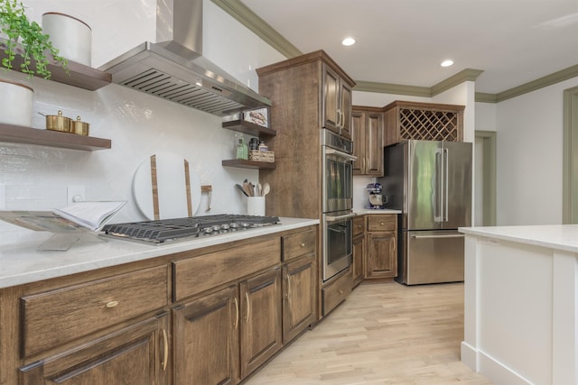 kitchen with crown molding, light hardwood / wood-style flooring, stainless steel appliances, light stone counters, and island range hood