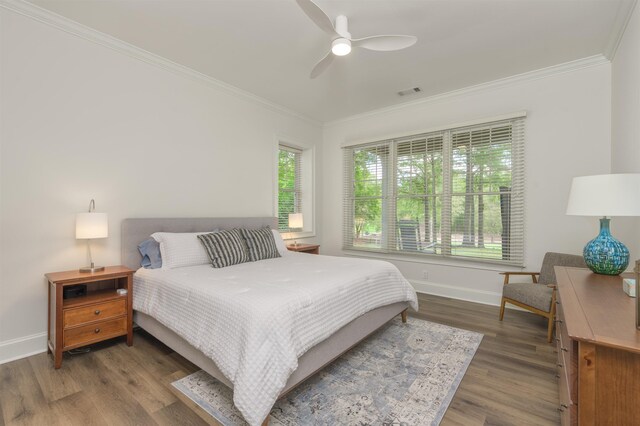 bedroom with hardwood / wood-style flooring, ornamental molding, and ceiling fan