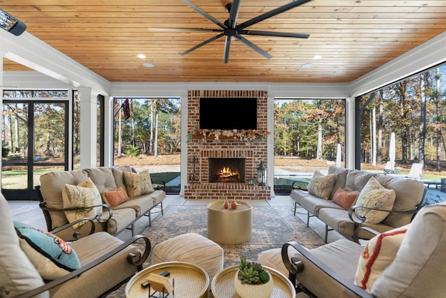 sunroom / solarium with an outdoor brick fireplace, ceiling fan, and wood ceiling