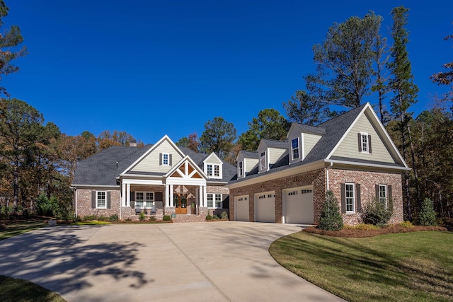 view of front of property featuring a porch, a garage, and a front lawn