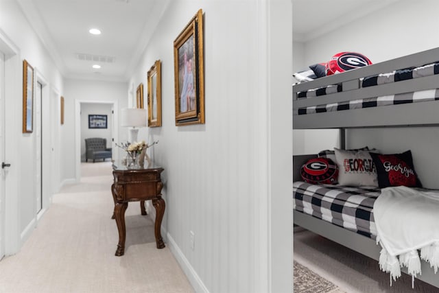 bedroom with ornamental molding and light colored carpet