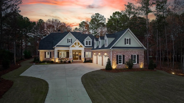 craftsman-style house featuring a garage, covered porch, and a lawn