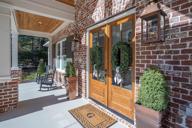 entrance to property with french doors and a porch