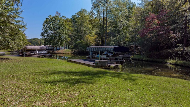 view of community featuring a lawn, a boat dock, and a water view