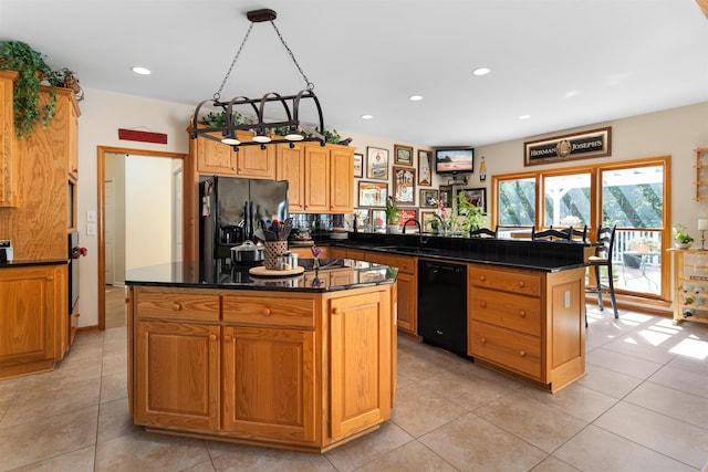 kitchen featuring sink, a center island, hanging light fixtures, kitchen peninsula, and black appliances