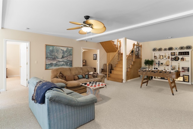 living room featuring beamed ceiling, light colored carpet, and ceiling fan