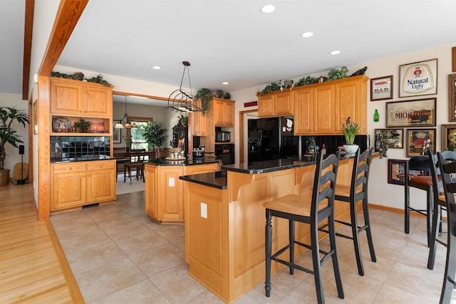 kitchen featuring pendant lighting, a breakfast bar, a center island, black appliances, and kitchen peninsula