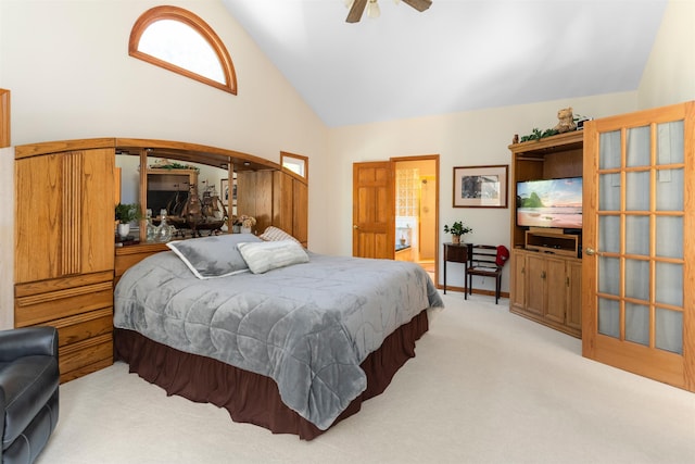 carpeted bedroom with connected bathroom, high vaulted ceiling, and ceiling fan