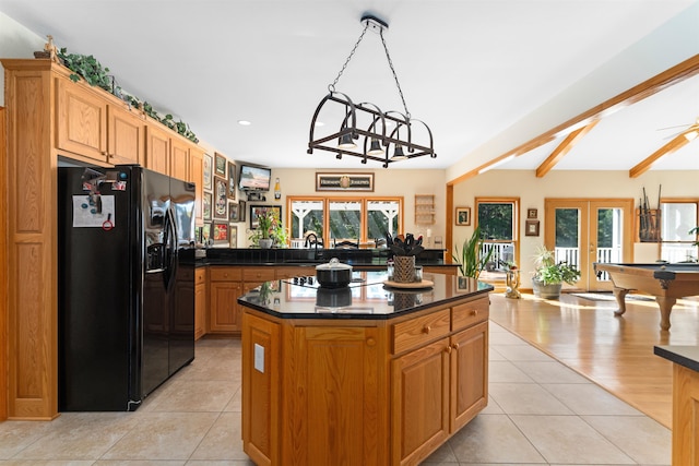 kitchen with black fridge, kitchen peninsula, french doors, and light tile patterned floors