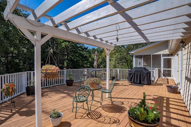 deck featuring a sunroom, area for grilling, and a pergola