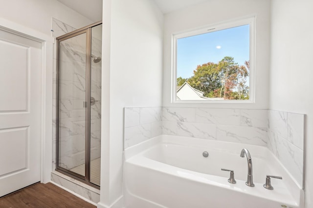 bathroom featuring wood-type flooring and plus walk in shower